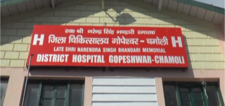 बारिश से क्षतिग्रस्त अस्पताल की गिरी हुई दीवार और मौके पर जुटे लोग